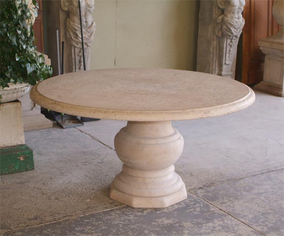 An elegantly carved round limestone table. Baluster base.