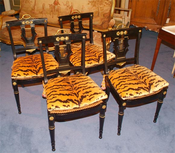 Ebonized side chairs with brass mountings, lyre motif back, velvet faux tiger print Brunschwig & Fils fabric cushions with tassles and ties, hand-caned seats.