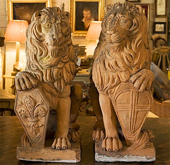 19th century French pair of sitting terra cotta statues of lion with armorial shields.