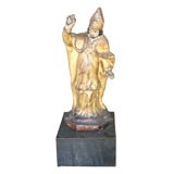 Giltwood statue of a robed bishop.