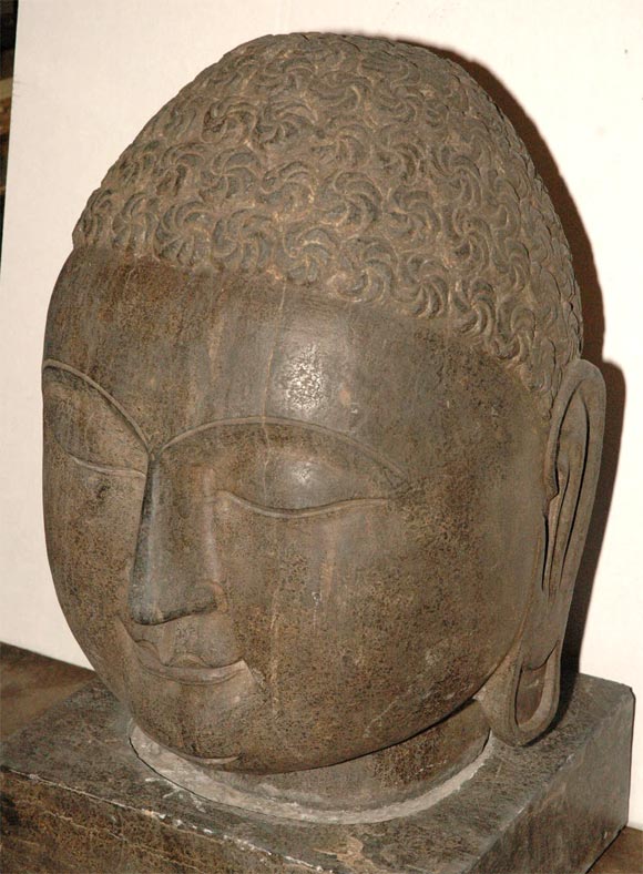 A very finely carved hard stone head with separate stone base.  The deity skillfully executed with a serene, pleased<br />
and meditative facial expression.