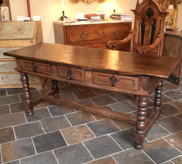 Late Renaissance period Italian baroque walnut refectory table, with three drawers and original hardware on legs separated by single stretcher.