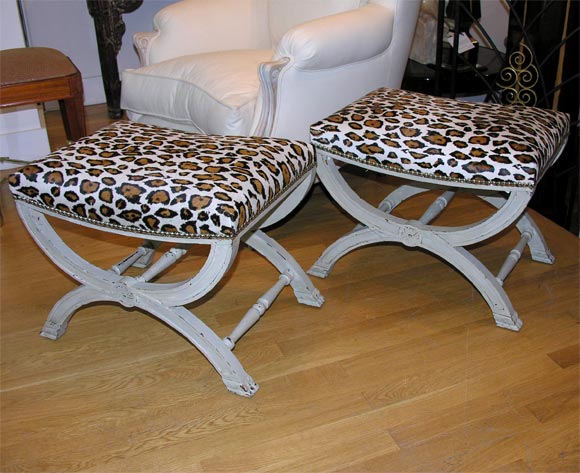 Stylish pair of whitish/gray painted stools. Newly upholstered seats in leopard printed calf skin with nailhead details on an 'X' stretcher.