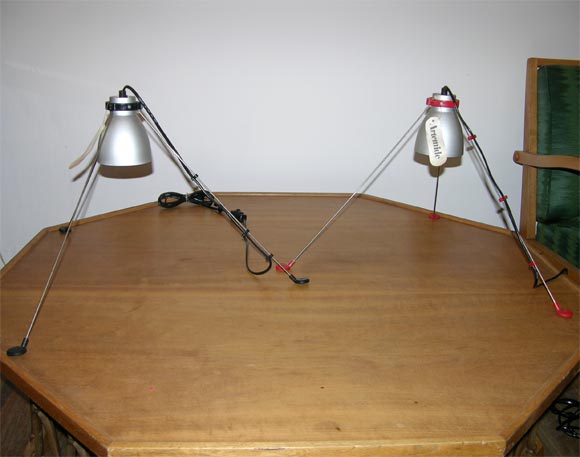 Funky pair of space-age style lamps designed by H.Tew for Artemide.  Attachable metal rod legs on colored plastic feet and silver lacquered metal shade.  Artemide label.  May be sold individually.