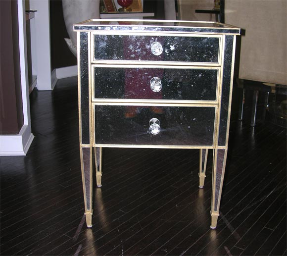 Custom commodes with distressed mirror. Gold leaf wood trim. Glass knobs
