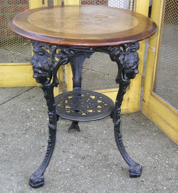 Cast iron decorative base with inlaid mahagony top.