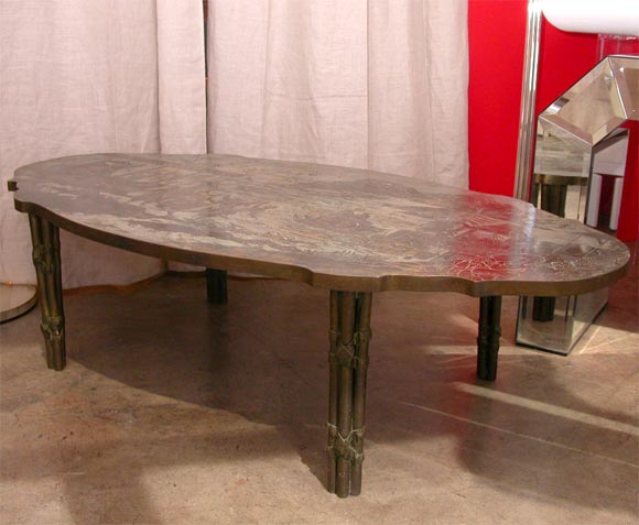 A rare and elegant coffee table by philip and kelvin laverne<br />
the bronze scalloped oval top inscribed with a scene representing a landscape ,an oriental scene of a lake with figures,the top ,with a silvered patina,isresting on 4 bronze  legs