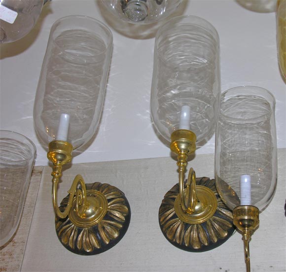 pair of sconces with large glass globes and wood backplates