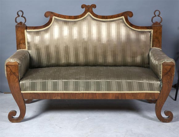 Austrian Biedermeier settee of unusual form. Walnut frame with upholstery that needs to be re upholstered. Some repair to the finials.