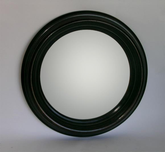 A Striking Mahogany Large Convex Mirror with bevelled glass and carved relief frame.