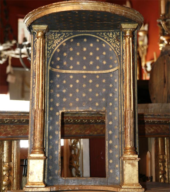Niche or alcove, background painted with gold stars, flanked by two fluted giltwood columns. The back is straight across (visually it appears to be demilune).