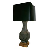 LARGE GEOMETRIC CERAMIC LAMP MOUNTED ON A GOLD LEAFED BASE.
