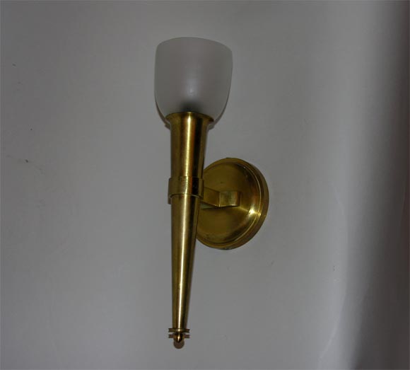 Single arm gilded sconces with frosted shades.