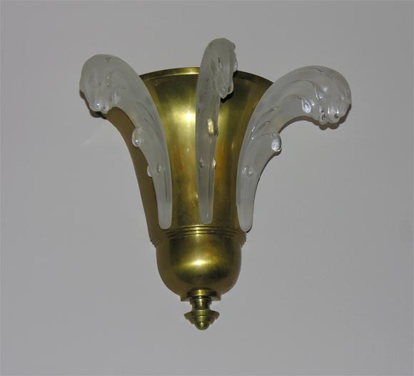 A pair of French Art Deco wall sconces comprised of three protuding molded glass panels mounted in a gilt brass frame.