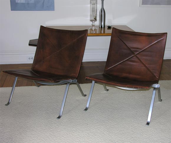 Pair of brown leather lounge chairs by Poul Kjaerholm, with extraordinarily rich patina to leather.  Elegant and comfortable.  Manufacturer's mark impressed to underside.