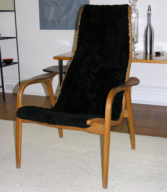 An enveloping easy chair by Yngve Eckstrom for Swedese.  A rich teak frame supports a cozy sheepskin sling.  Excellent for reading and relaxing.<br />
<br />
Two available:  One in black sheepskin, the other in brown.<br />
Manufacturer's and
