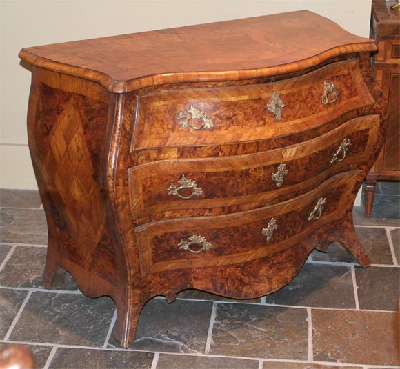 Swedish rococo pollard oak, birch, and elm bombe commode, the serpentine-outlined banded top, raised above three drawers, the sides inlaid with parquetry diamonds, the legs outswept.