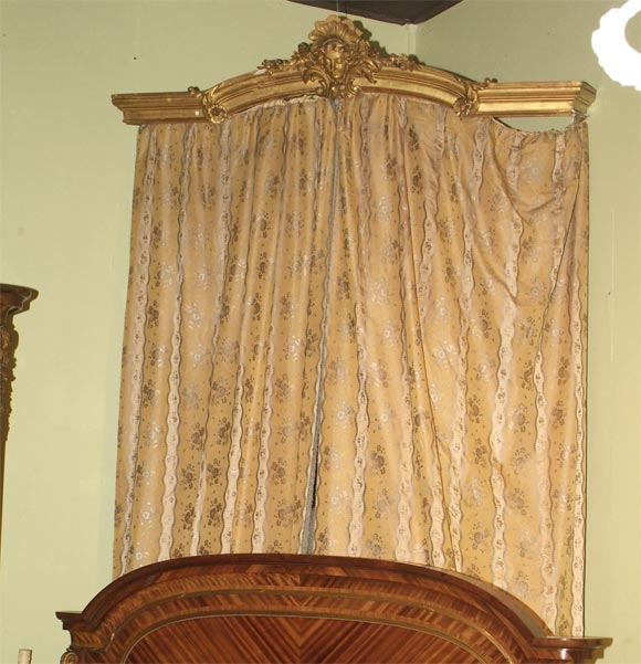 ELABORATELY CARVED AND WATER GILT CORNICES WITH A CENTRAL MASK FLANKED BY LYRICAL FOLIATE SCROLLS, ACANTHUS AND FLOWERHEAD DECORATION.