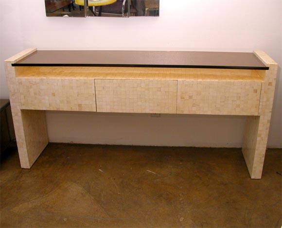 Beautiful drawered console with a smoked glass top and square horn tile wrap.