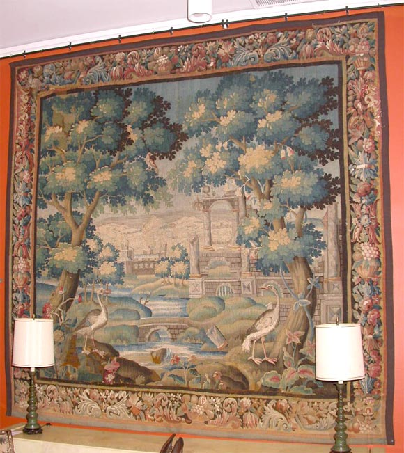 this extraordinary tapestry is Woven with two large birds(cranes)standing on rocks of a garden<br />
with various horizontal architectural neoclassic  ruines and colonnades and a fortresse  flanking a waterfall and a pond <br />
in the middle of a