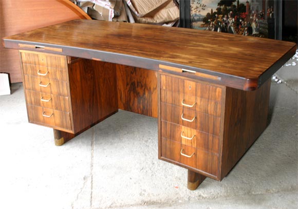 Handsome, high quality Danish modern desk by Jacob Kjaer from the 1940's in figured rosewood with brass handles and shoes.  Slightly curved with writing slides, tambour doors and slide on the back side, cupboards for storage.