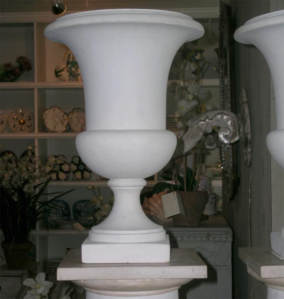 Highly desireable pair of French Plaster Urns which are electrified on plaster plinths with faux marble bases