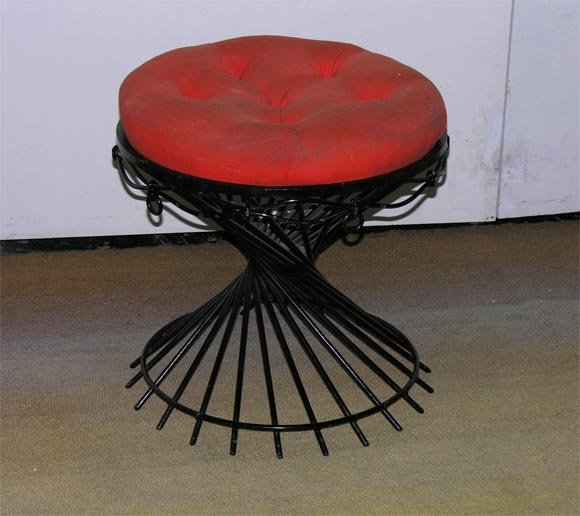 Stool made of sculpted and lacquered metal with an orange seat