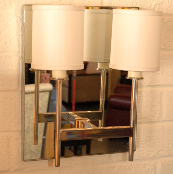 Two-Arm Mirror Back Sconce by Paul Marra. Steel frame with inset clear mirror. Also available as one-arm. Price quoted is per each.  Available by order only.