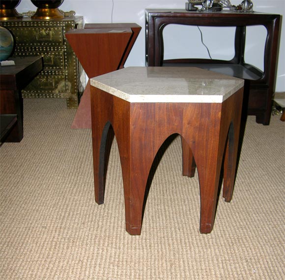 A pair of hexagonal occasional tables with travertine marble tops and arch motif walnut bases, American, circa 1950.