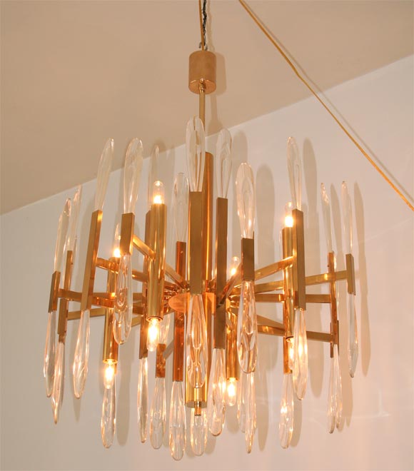 Brass and 36 cast glass crystals in abstract elongated leaf form 8 light multi arm chandelier.