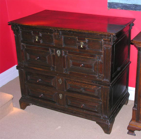 An English 17th Century two part geometric molded chest of drawers in oak with snakewood and bog oak panels, original (save one) turned yewwood acorn pulls