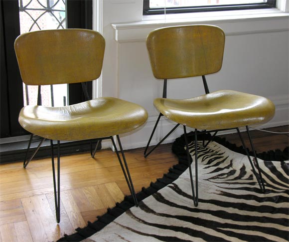 Wonderful pair of textured fiberglass lounge chairs, designed by Greta Grossman and manufactured by Chemold of Santa Monica, California, in the 1950's.  Beautiful caramel color with inset textural mesh; black iron hairpin legs and back support. 