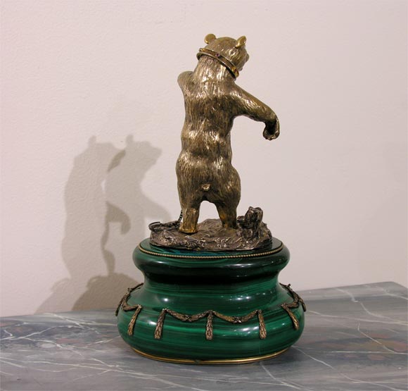 A gilt bronze dancing bear with small ruby stones on the collar and eyes, set on a decorated, solid  Malachite base.  The Malachite base of a later date.