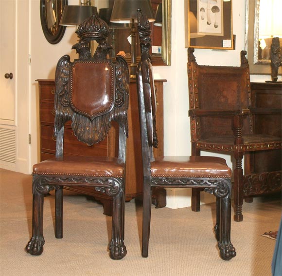 Boldly carved and scaled Habsburg double headed eagle armorial chairs.  Upholstered in leather.  They where purchased from the prop department of MGM studios.