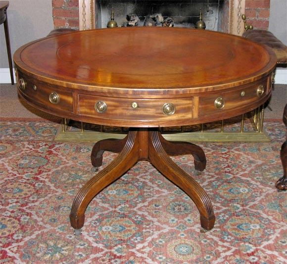 Classic English Drum Table, <br />
Round top with eight drawers, <br />
Supported by a four fluted <br />
Leg Pedestal,Regency Period, <br />
(Leather later with gilded, foliate design)