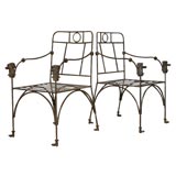 pair wrought iron "dog" armchairs