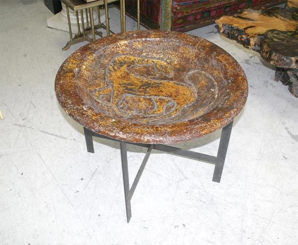 Modernist terra cotta glazed bird bath depicting a horse in the centre of the vessel. Vessel sits atop its original iron Stand. Would also make a wonderful coffee table or catch all for magazines and books. In the manner of Raymoor.