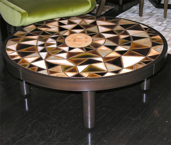 table inhabituelle en carreaux de Roger Capron, le centre est un visage naïf du soleil