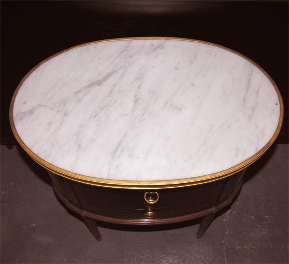 A Pair of Mahogany and Walnut Louis XVIth small Oval side tables with gilt-bronze mounts and a white marble inset top.