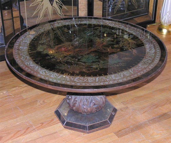 Circular glass top cocktail table featuring an elaborate verre eglomise chinoiserie design.