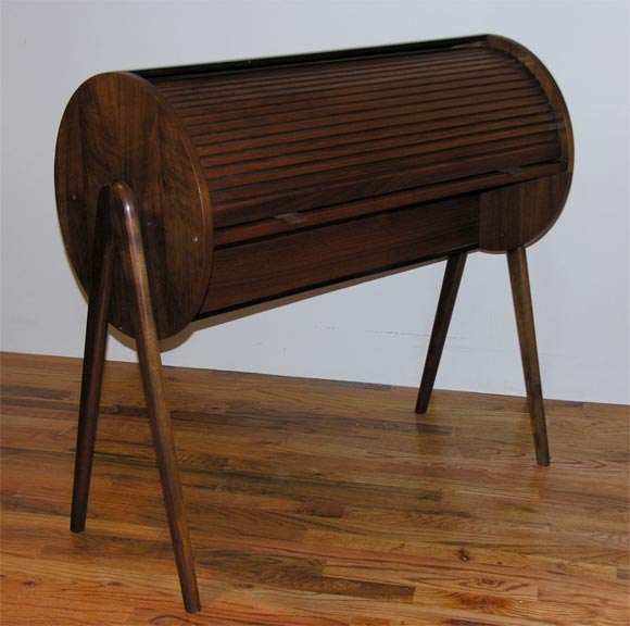Small-scale and unusual barrel shaped desk with compass legs and tambour roll-top. Has slots for letters and papers.  Good size<br />
for laptop.  Made of walnut in excellent original condition.