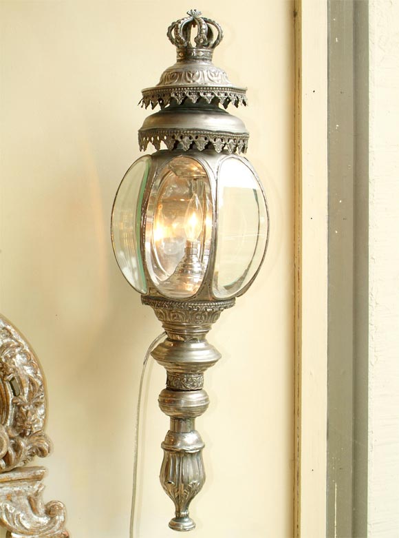 Pair of Italian (Venetian) silvered metal carriage lanterns, each with a septagonal-shaped ovoid lantern, surmounted by a crown and two foliate-scrolled tiers, raised on a turned base, ending in a cast finial.