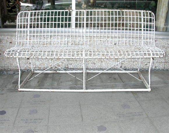 American wire garden bench circa 1930. Iron frame with 3 legs attached to frame. Heavy woven wire back and seat with old white paint.