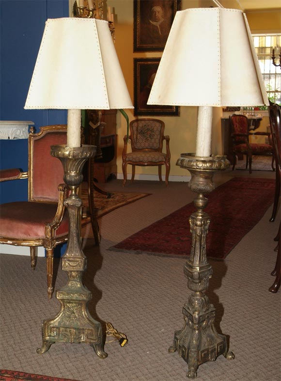 TWO SIMILAR BUT NOT IDENTICAL GILT METAL REPOUSSE ALTAR STICKS CONVERTED INTO FLOOR LAMPS. HANDMADE PARCHMENT SHADES FROM PERU.<br />
PRICE QUOTED IS FOR EACH LAMP.