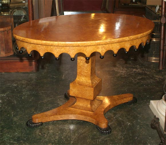 A highly unusual oval shape Biedermeier style center table made of exotic burled amboyna wood. Having a scalloped apron ending with ebonized orbs, supported by an elliptical center column on oval ribbed pad feet. 
Mid to Late 19th Century, Northern