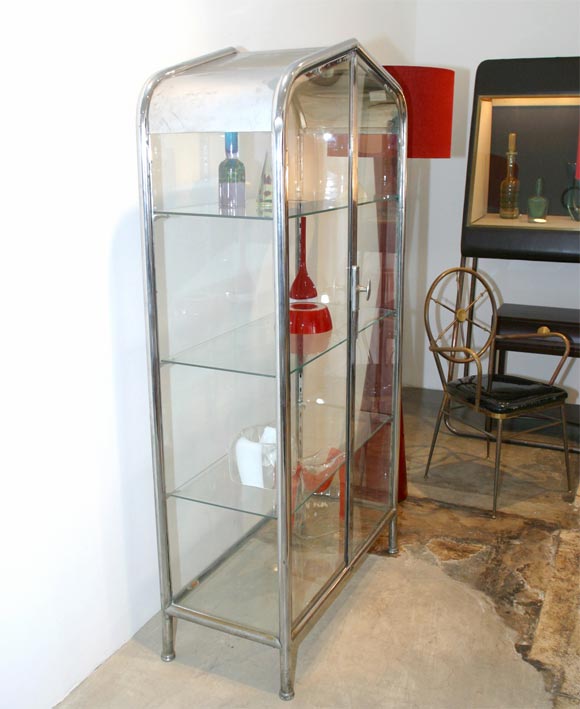 This is a beautiful glass and metal display cabinet with glass shelves.  It has a locking mechanism and two doors that swing open.