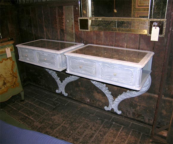 Églomisé inset mirror tops. Right and left mounted tables, each having one drawer and one open shelf. Foliated carved wood decorative legs. Decorative carvings. Blue and grey painted with limed highlights.