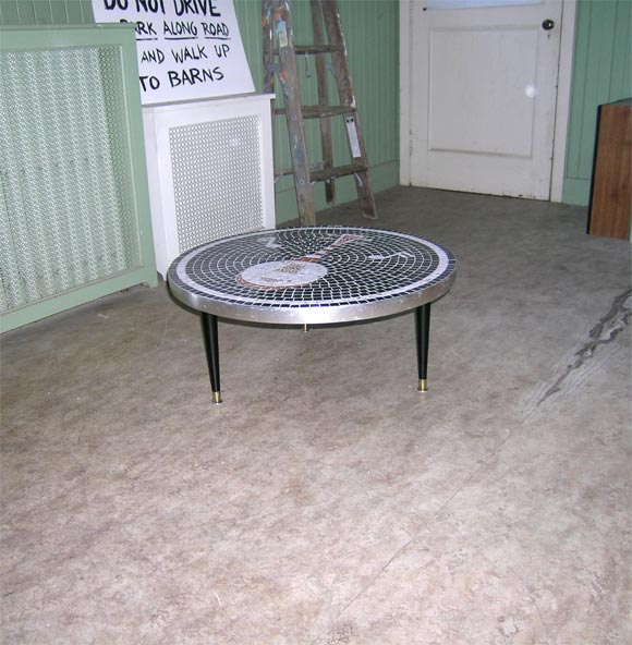 Black and white mosaic tile top low table with musical notes and banjo design. Metal perimeter, black painted wood legs with metal feet.