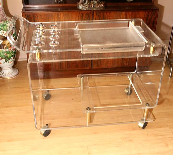 Lucite trolley, bar, with space for glasses, and inset tray, on brass wheels and with brass fitments.  Smooth rolling action.  Mid century modern