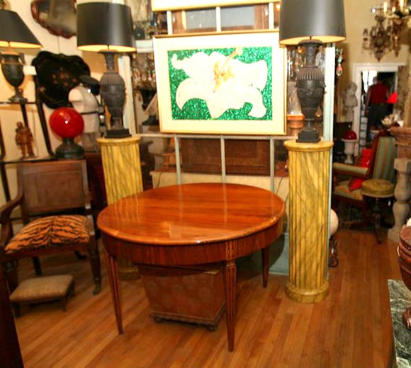 A round walnut table withsolid wood top, wasting fluted legs and highly figured apron